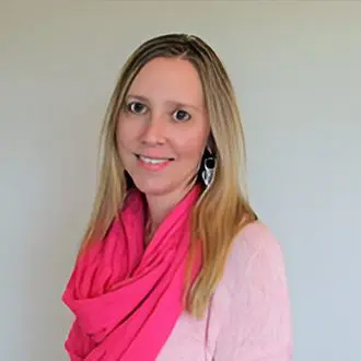 A woman wearing a pink scarf and white shirt.